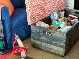 From the moment he wakes up each morning, Cooperâ  s toys immediately take over the family room. To keep them within armâ  s reach, yet concealed safely, a coffee table was made from a basic pine toy box updated with small strips of reclaimed pine flooring and tacks.